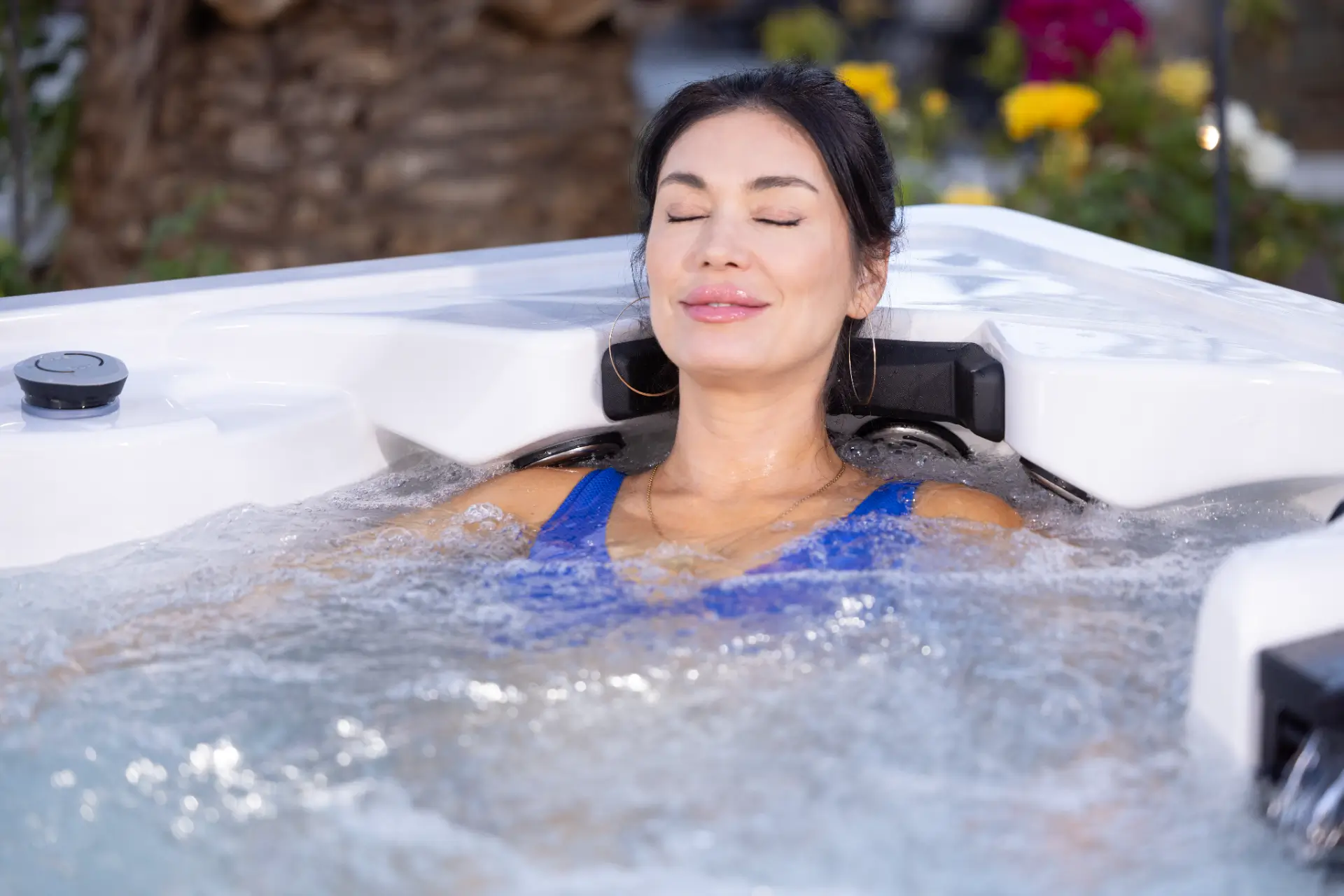 Woman relaxing in hot tub with water features, showcasing spa experience by Creative Hot Tub Designs in Reno, NV.