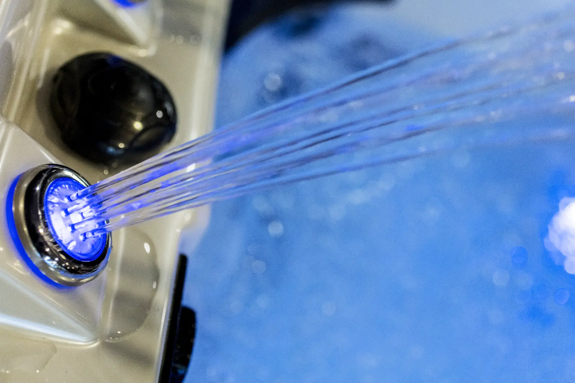 Hot tub water feature with illuminated jets and blue lighting, showcasing a luxurious spa experience by Creative Hot Tub Designs in Reno, NV.